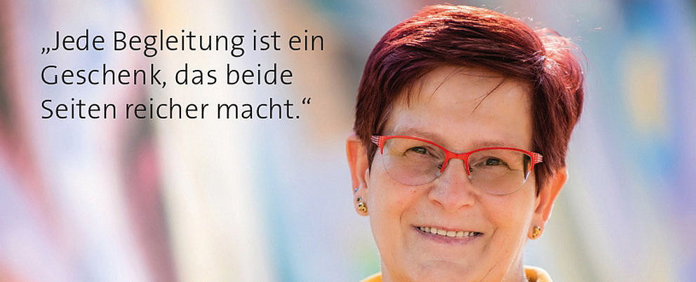 Person mit kurzen roten Haaren und gelbem Hemd vor unscharfem Hintergrund, daneben der Text ‚Jede Begleitung ist ein Geschenk, das beide Seiten reicher macht.‘